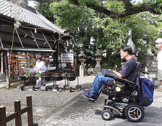 神社の中での岸和田祭を見つめる車椅子の方を、横からみた写真